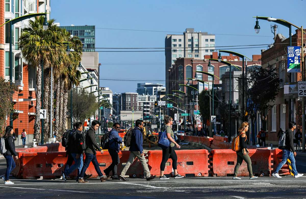 People walk past the construction for the Central Subway at 4th and Bryant Streets in San Francisco, California, on Thursday, Aug. 16, 2018.