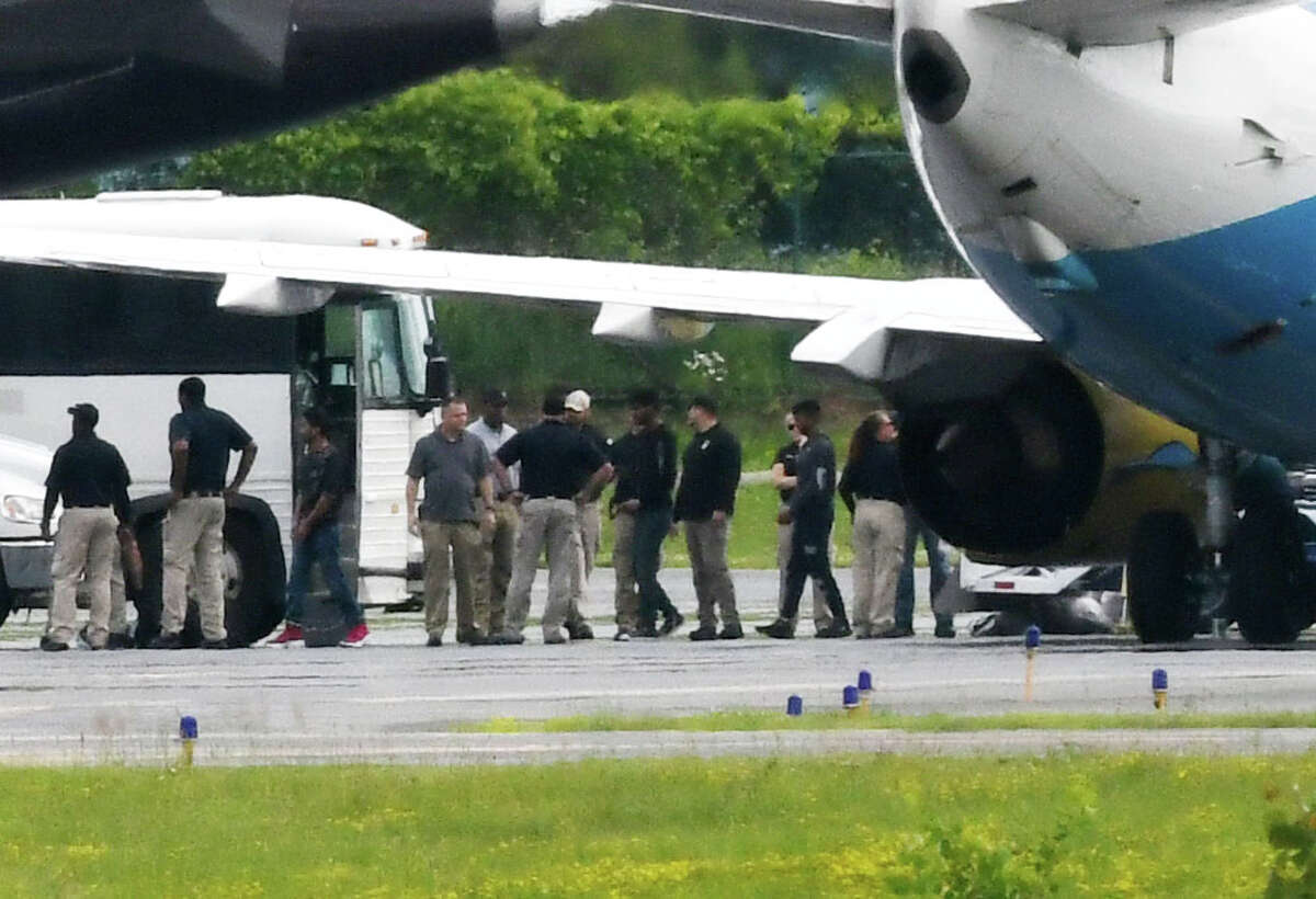 Immigrant men are escorted off a U.S. Immigration and Customs Enforcement jet from Arizona at Albany International Airport during their transport to Albany County Jail on Thursday afternoon, June 28, 2018, in Colonie, N.Y. The jail has taken in 235 immigrant men who are being detained on immigration charges. (Will Waldron/Times Union)