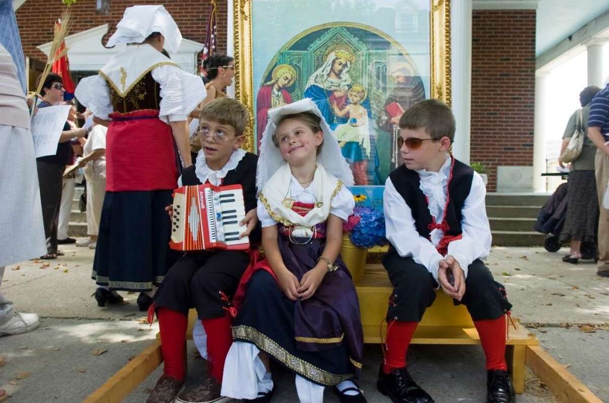 Nicky, 9, left, and Ariana Corrente, 6, and Nicky Palumbo, 7, relax after marching in the Minturnese Club's annual Festa de la Regne or "Festival of Wheat" parade beginning and ending at Sacred Heart Church on Schuyler Avenue Sunday, July 11, 2010. La Madonna dele Grazie, or the Blessed Mother, is the patron saint of Minturno, Italy where she is venerated on the second Sunday of July each year. The fete also marks the harvest of wheat which adds additional reason to the celebration of the Lady of Graces who the Minturnese thank for her generosity in their bounty.