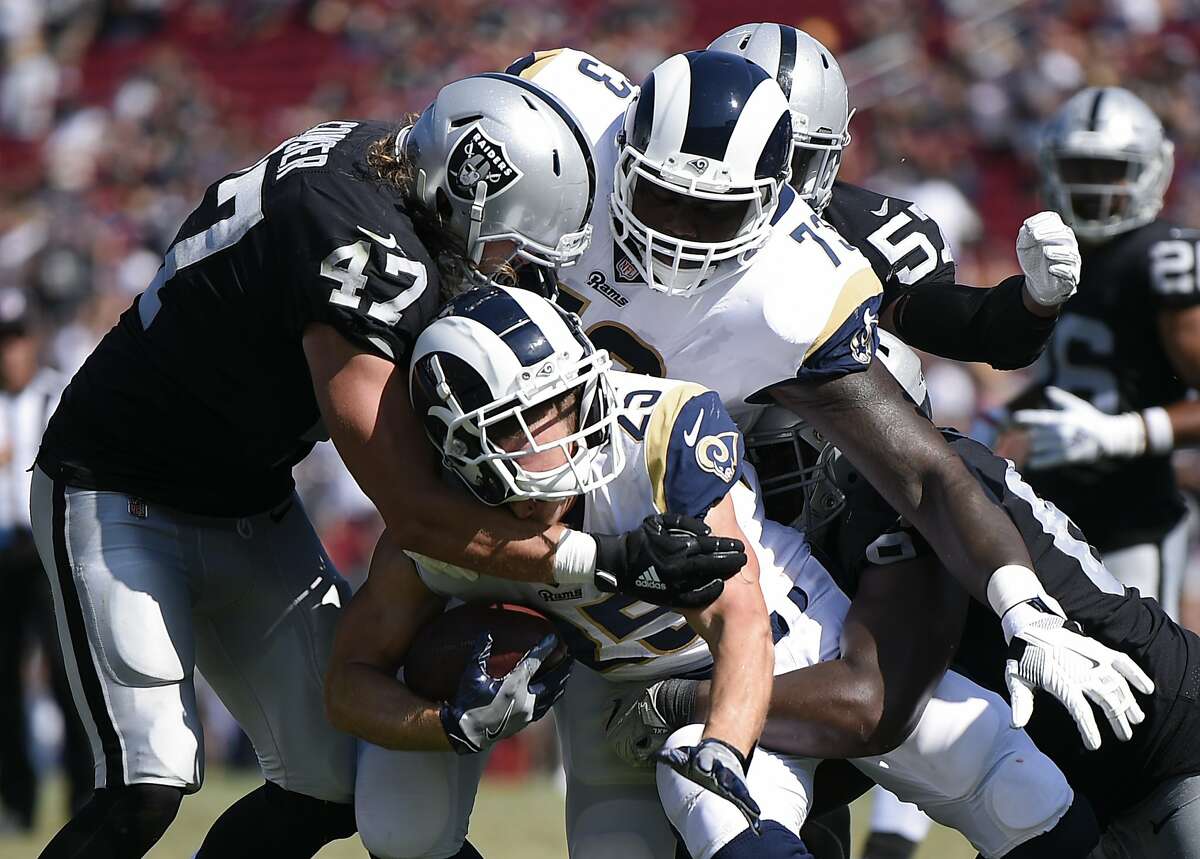 Los Angeles Rams running back Nick Holley runs the ball defended by Oakland Raiders linebacker James Cowser during the second half in an NFL preseason football game Saturday, Aug. 18, 2018, in Los Angeles. (AP Photo/Kelvin Kuo)