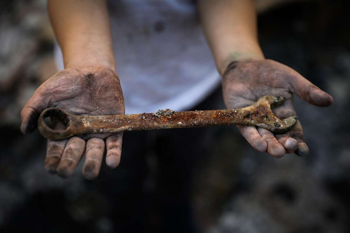 Daniel Wood, 5, shows off a wrench he found while sifting look through the destroyed remains of his home on Harlan Drive in Redding, California, on Thursday, Aug. 23, 2018.