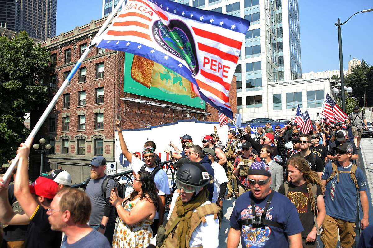 Protesters from right-wing groups Washington 3 Percenters and Patriot Prayer march down Yesler Way during a "Liberty or Death" rally at Seattle City Hall, in part, to oppose Washington gun-control Initiative 1639, Saturday, Aug. 18, 2018. Counter-protesters lined the other side of the street, at least two men were arrested. (Genna Martin, seattlepi.com)