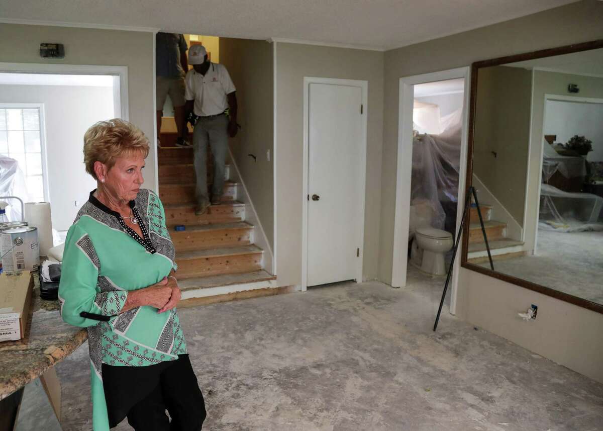 Martha Arvidsson waits in her home as her two new contractors, Homer Wilson and Jeremy Hawkins, in background, tour her home, Friday, Aug. 17, 2018, in Dickinson. Arvidsson hired a contractor after Hurricane Harvey, and she says he did shoddy work.