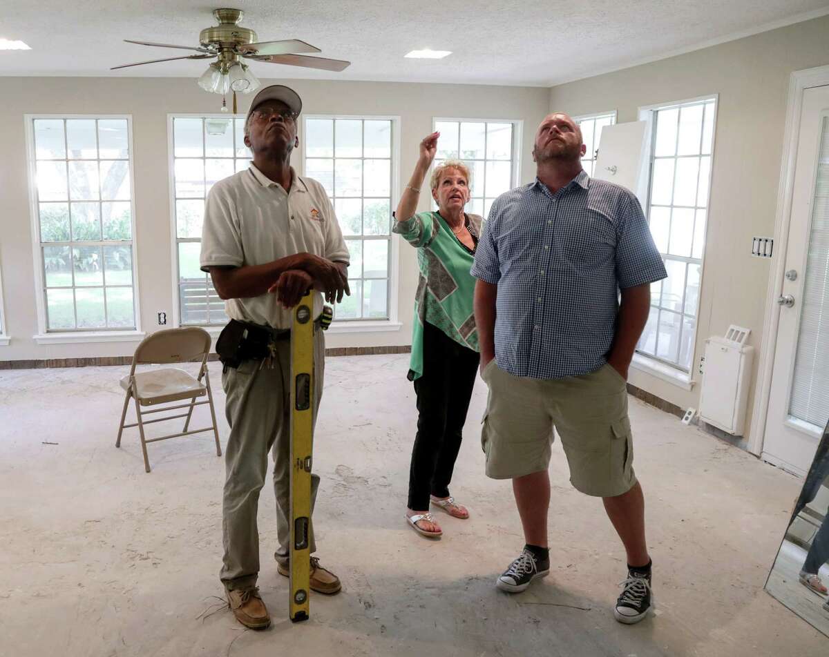 Arvidsson and her new contractors, Homer Wilson, left, and Jeremy Hawkins, examine the work of a previous contractor.