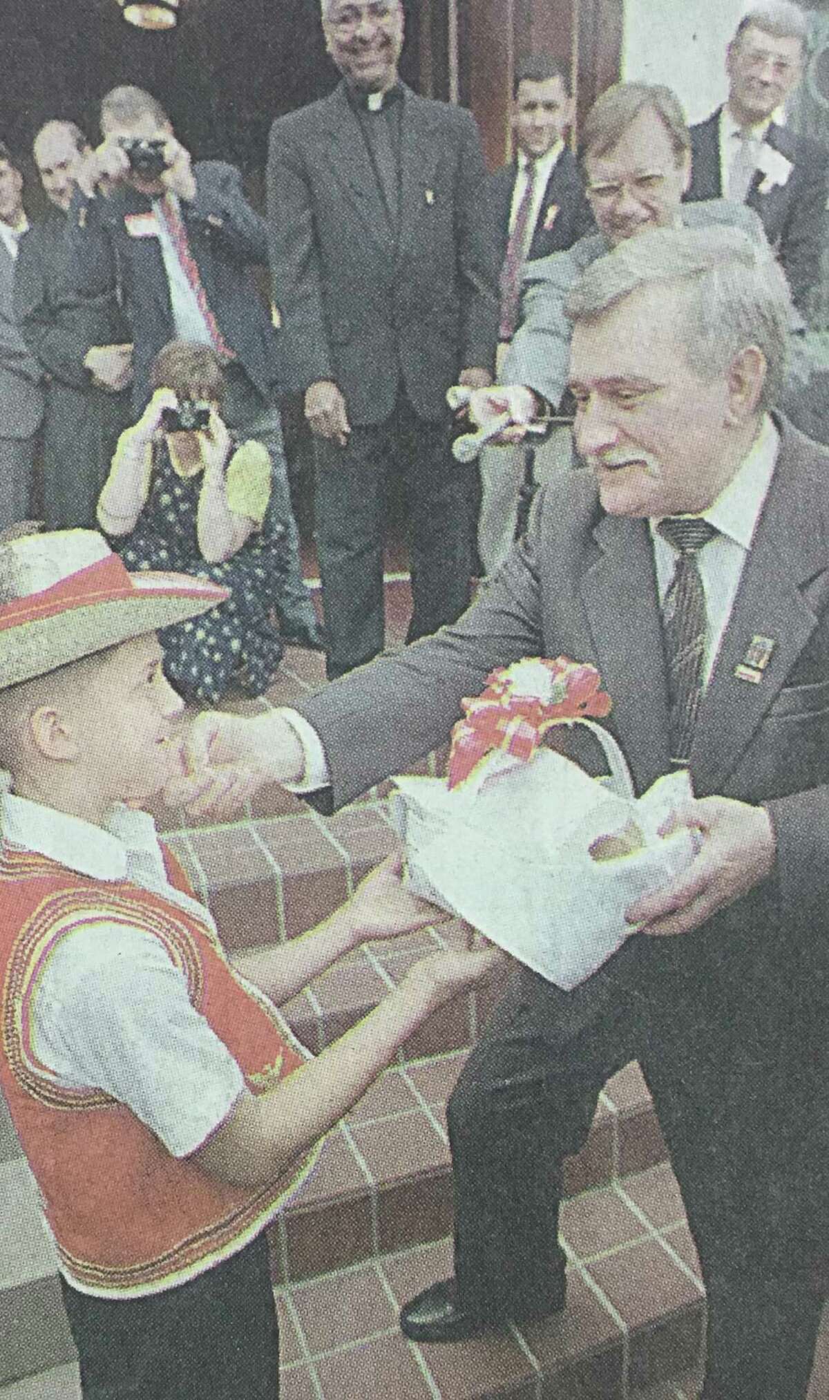 Lech Walesa, the former president of Poland, accepts a traditional Polish gift of bread and salt from Justin Halter, 10, outside of New Waverly's St. Joseph Catholic Church in October 1996.
