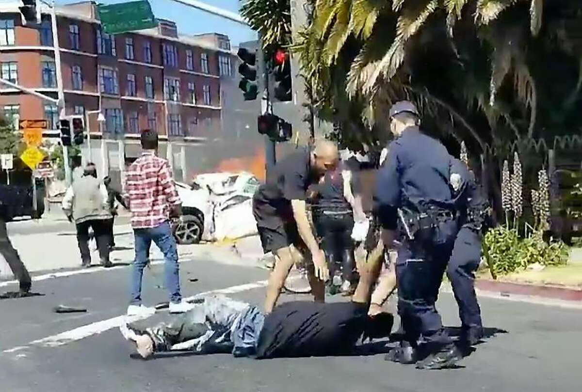 Police and bystanders drag 42-year-old Michael Brown from a burning car in Emeryville on June 10.