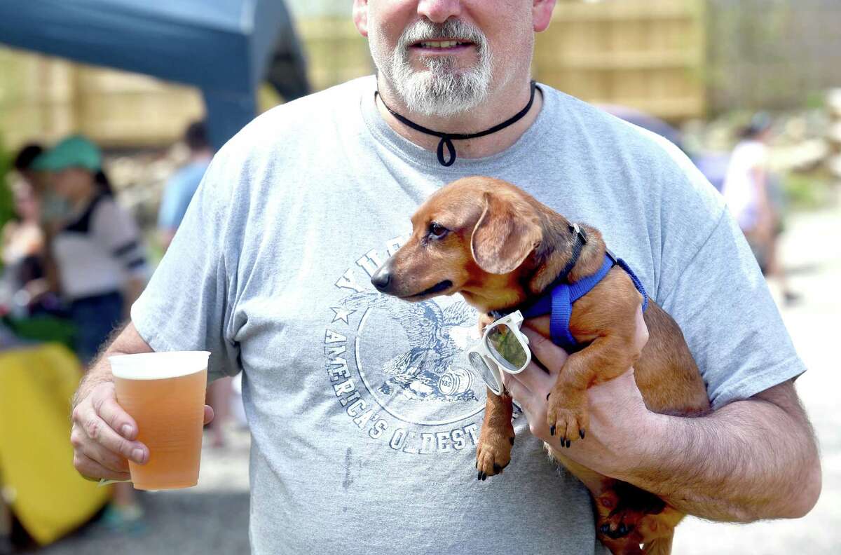 (Arnold Gold-New Haven Register) Joel Kondra of Manchester carries his miniature dachshund, Bullet, and a Sixpoint Brewery beer during the Beers for Beasts event at The Hops Company in Derby to benefit the Shelton Animal Shelter and the Friends of New Haven Animal Shelter on 4/29/2017.