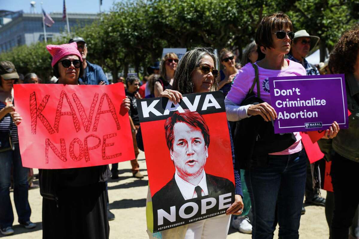 Christine Zerrer (left) and Sandra Messer (center) listen during the Unite For Justice rally promoting women’s equality and protesting the Supreme Court nomination of Brett Kavanaugh outside City Hall in San Francisco.