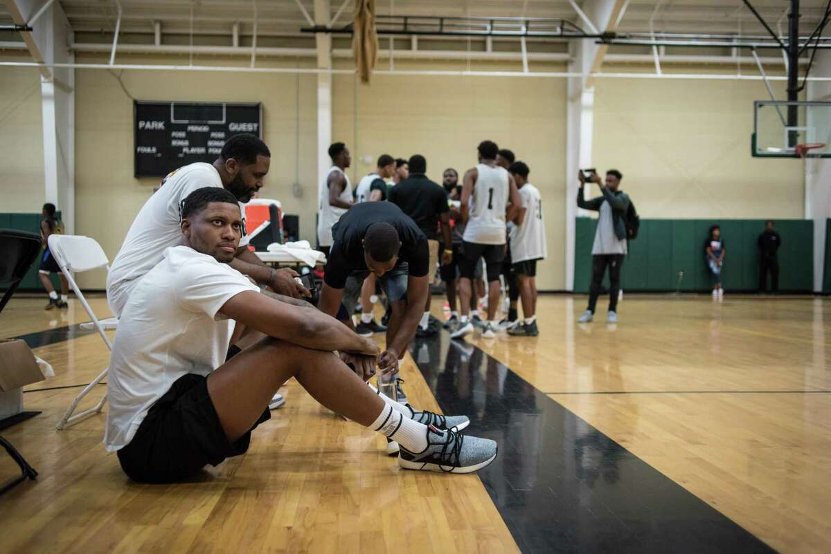BALTIMORE, MD -- 8/18/18 -- Rudy sits on the floor next to Jimmy Price, his skills trainer, as they watch a game. Spurs forward Rudy Gay returns to his hometown of Baltimore to host the Flight 22 Foundation tournament to showcase local youth. Gay's philanthropy extends throughout the city, where he has refurbished playgrounds, partnered with Target to give away gifts at Christmas, and other charitable works.…by André Chung #_AC15116