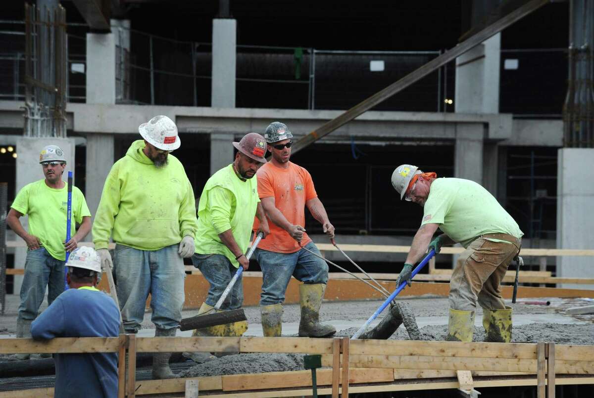 Construction workers lay concrete in May 2018 in Norwalk, Conn.