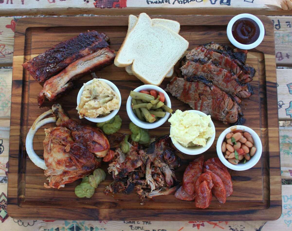 The board at Bad To The Bone BBQ includes (clockwise from top left): St. Louis-style pork ribs, brisket, pinto beans, sausage, potato salad, pulled pork, green beans, chicken and baked potato casserole.
