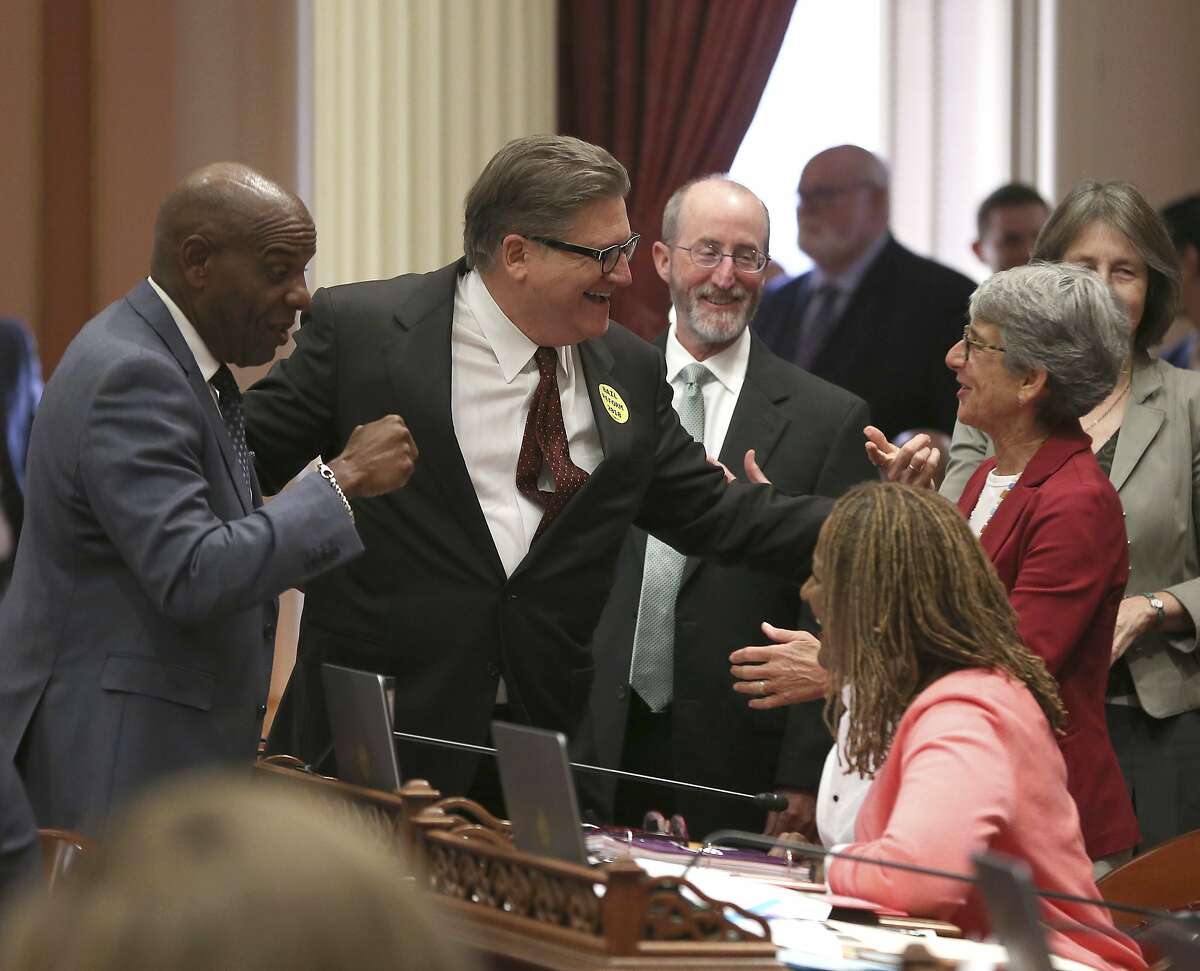 State Sen. Bob Hertzberg, D-Van Nuys, second from left, receives congratulations from fellow Democratic state Senators, Steven Bradford, of Los Angeles, left, Steve Glazer, of Orinda, third from left, and Hannah-Beth Jackson, of Santa Barbara, right, after his bail reform bill was approved by the state Senate, Tuesday, Aug. 21, 2018, in Sacramento, Calif. If signed by Gov. Jerry Brown, it would make California the first state to completely end bail for suspects awaiting trial. (AP Photo/Rich Pedroncelli)