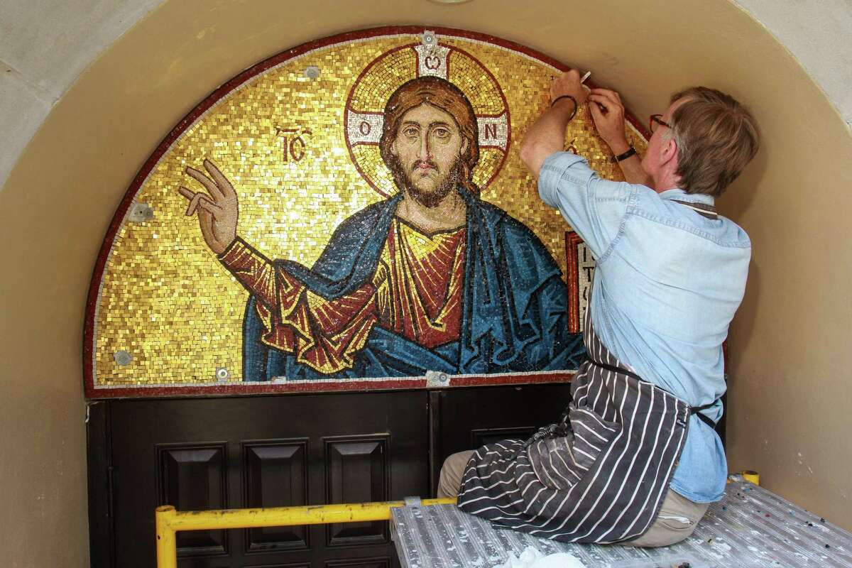 British artist Aidan Hart works from a scaffold as he puts the finishing touches on his "Christ Pantocrator" mosaic on the outside of St. George Orthodox Church.