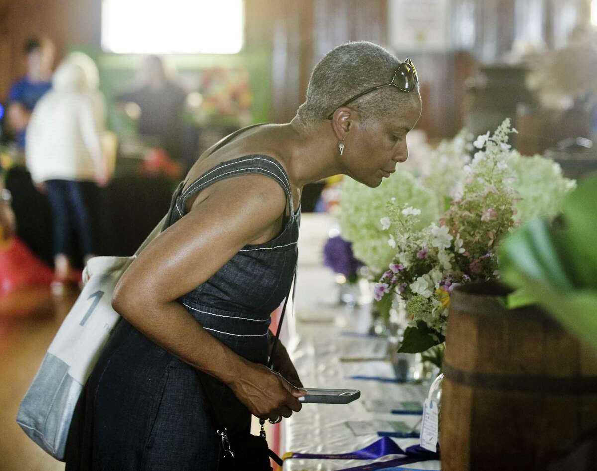 Stephanie Thomas, of Norwalk, looks over some flowers on display at the 86th Annual Cannon Grange Agricultural Fair in Cannondale. Sunday, Aug. 26, 2018