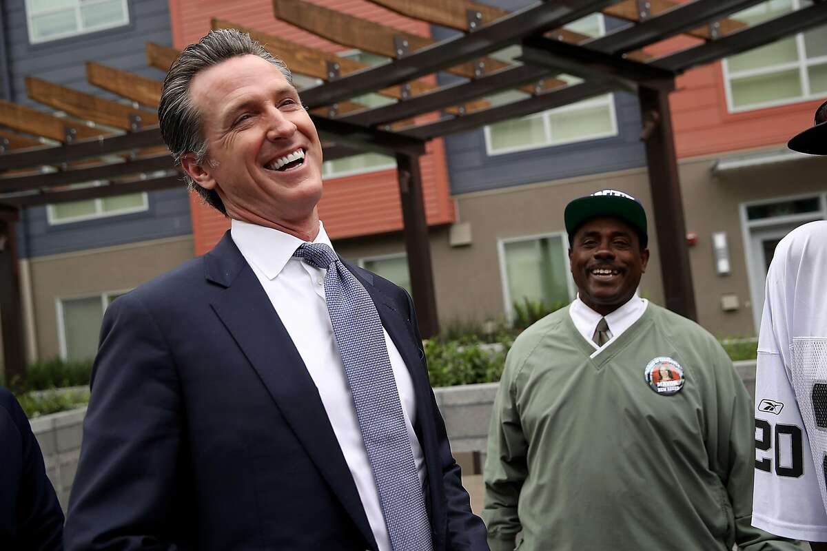 SAN FRANCISCO, CA - AUGUST 22: California Lt. Gov. and California gubernatorial candidate Gavin Newsom (L) laughs with a resident as he visits the Alice Griffith Apartments on August 22, 2018 in San Francisco, California. Lt. Gov. Gavin Newsom and San Francisco mayor London Breed toured a low-income housing complex. Newsom leads Republican gubernatorial candidate John Cox by an average of 23 percentage points in recent polls. (Photo by Justin Sullivan/Getty Images)
