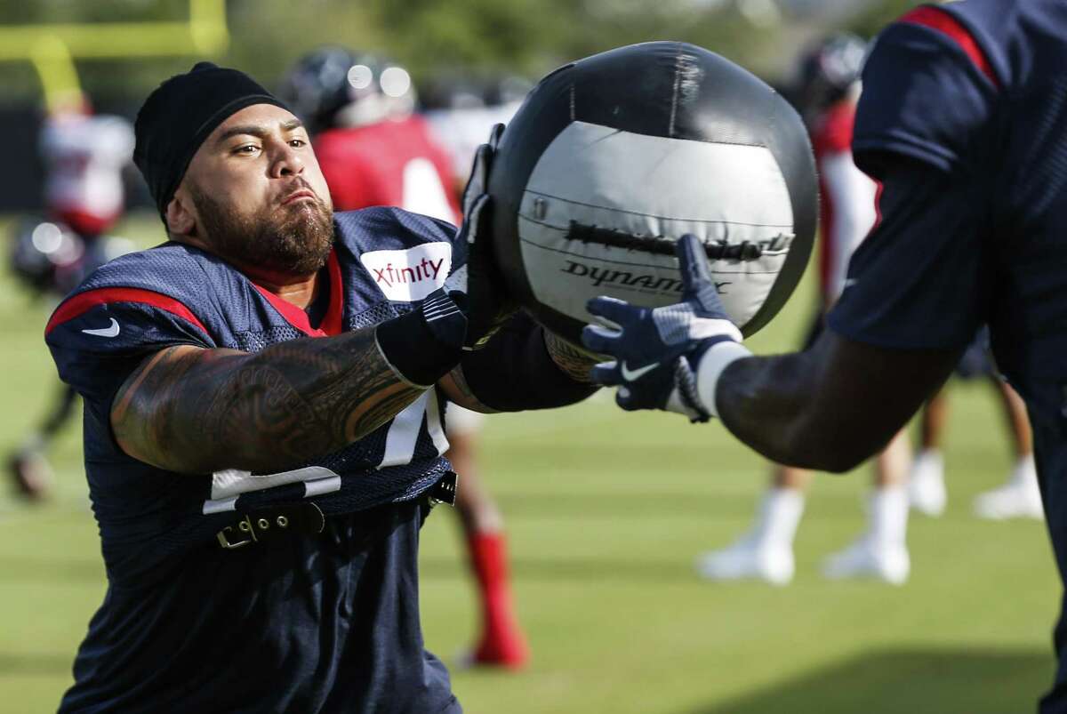 Guard Senio Kelemete gets a dose of medicine ball during a drill at Texans training camp.
