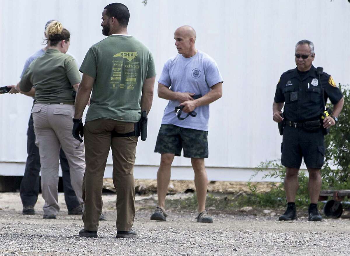 A man identified as Bradley Croft, second from right, talks with state and federal authorities serving a search warrant Wednesday, Aug. 8, 2018 at canine charity Universal K9, 15329 Tradesman, near Loop 1604 on the Northwest Side, as part of a federal investigation. Croft is a principal in Universal K9.