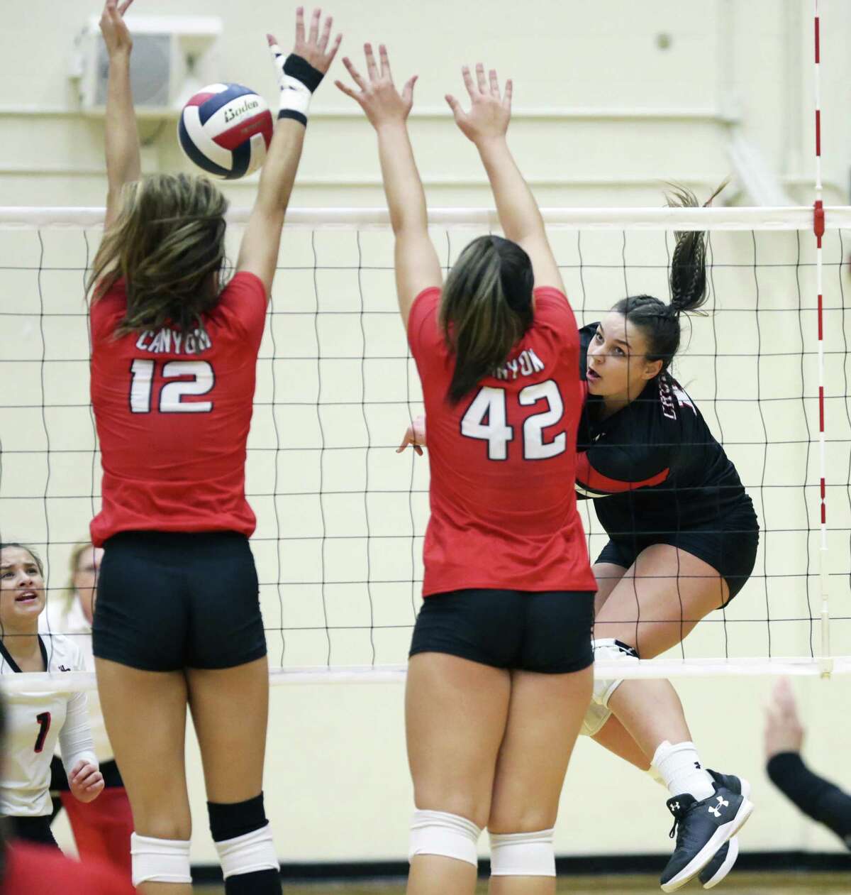 Churchill's Caroline Meuth fires the ball into Canyon blockers Angel Jones (12) and Erin Jones as Churchill hosts Canyon in volleyball at Littleton Gym on August 28, 2018.