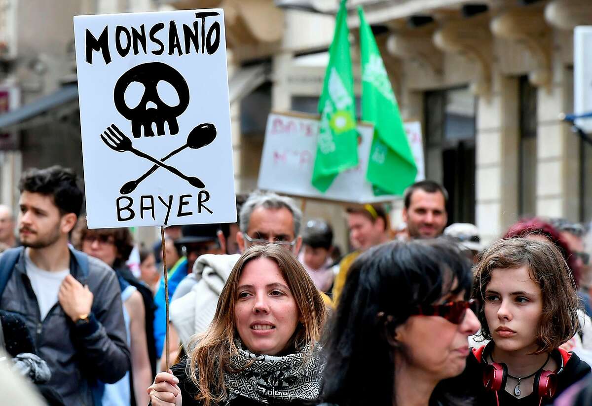(FILES) In this file photo taken on May 20, 2017, demonstrators walk with placards during a march for agroecology and civil resistance against seed and pesticide maker Monsanto in Bordeaux, southwestern France. - A cancer victim's surprise court victory over US pesticide maker Monsanto could open the floodgates to a slew of similar lawsuits, potentially leaving the firm's new German owner Bayer with a major case of buyer's remorse. (Photo by GEORGES GOBET / AFP)GEORGES GOBET/AFP/Getty Images