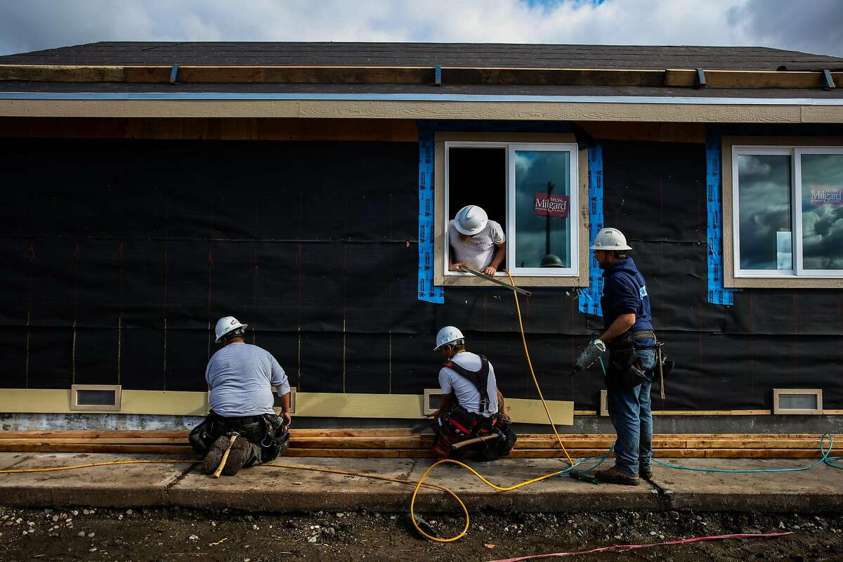 (l-r) Construction workers Victor Villanueva, Jared Ashworth, Rob Williams and Jesse Merritt work together to rebuild displaced resident Dan Bradford's (not pictured) home in the Coffey Park neighborhood of Santa Rosa, California, on Monday, Jan. 22, 2018. Dan Bradford's home is the first one in the neighborhood to be rebuilt after the Tubbs fire tore ravaged thousands of homes last October.
