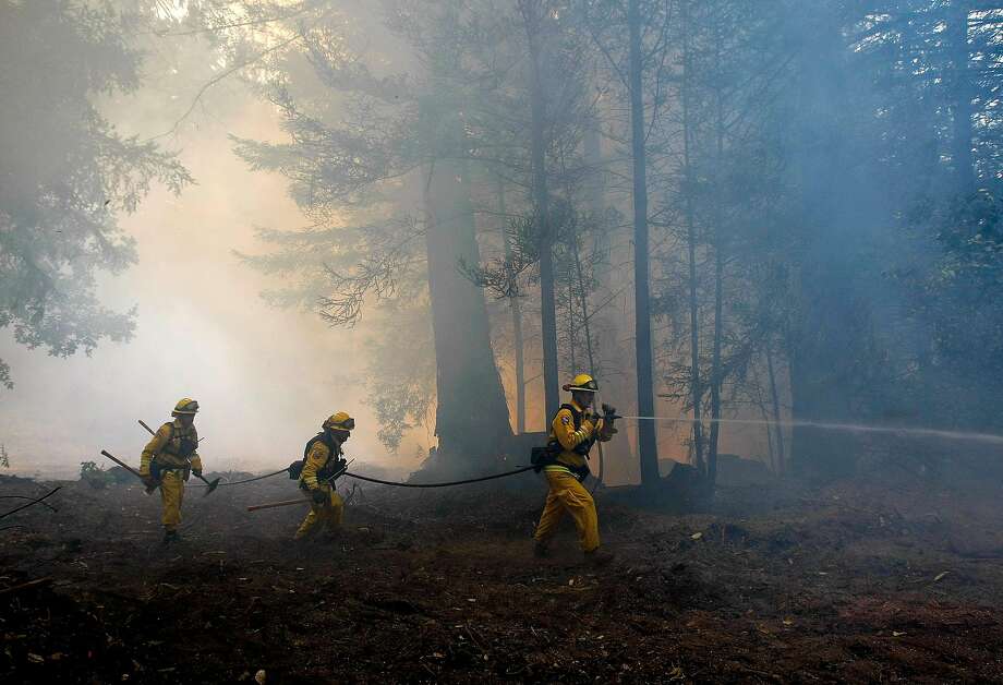 Matt Ramsey (left), David Lutz and Chris Leddy search for hot spots along Warnella Road, as firefighters continue to battle the Lockheed Fire on Friday August 14, 2009 in Bonny Doon, Calif. Photo: Michael Macor / The Chronicle 2009