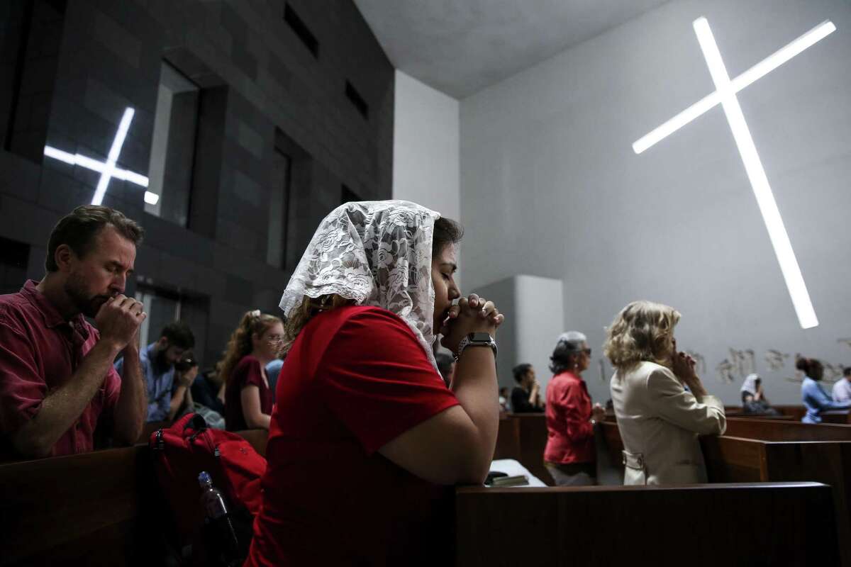 University of St. Thomas freshman Megan Perales prays during Mass at the Chapel of St. Basil Tuesday Aug. 28, 2018 in Houston. Church members have been shaken by a swirl of new allegations involving clergy sex abuse.