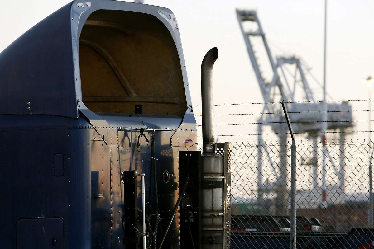 The exhaust pipe of a truck is seen with a container crane in the background at the Port of Oakland in Oakland, California Tuesday, September 17, 2013.