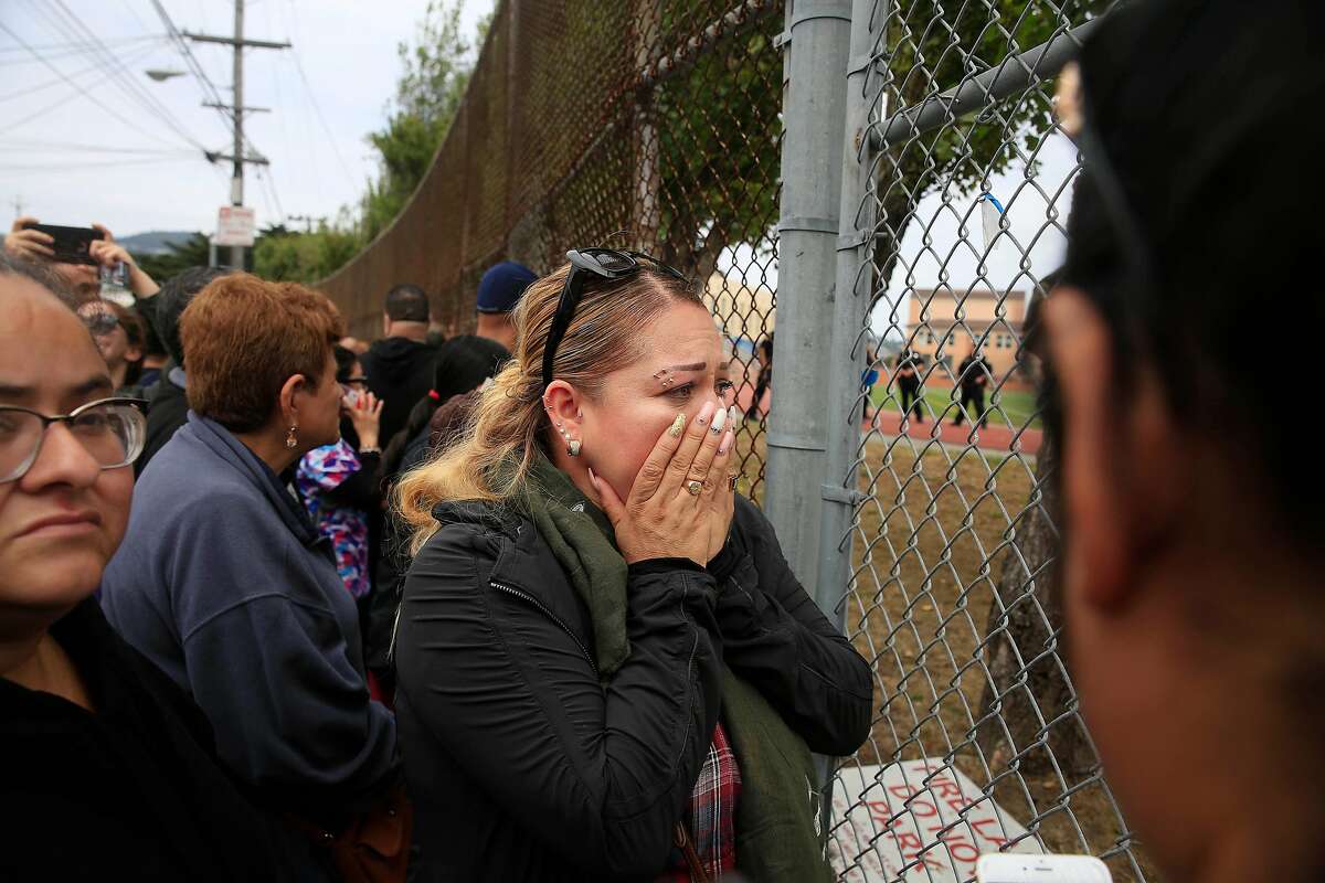 Nelly Lizama waits outside a gate at the football field as parents wait to be reunited with their children after a gun incident at Balboa High School on Thursday, August 30, 2018 in San Francisco, Calif. Multiple schools in the area near San Francisco's Balboa Park went into lockdown around noon Thursday after an "incident" that left one student injured, three persons detained and a firearm recovered, authorities said.
