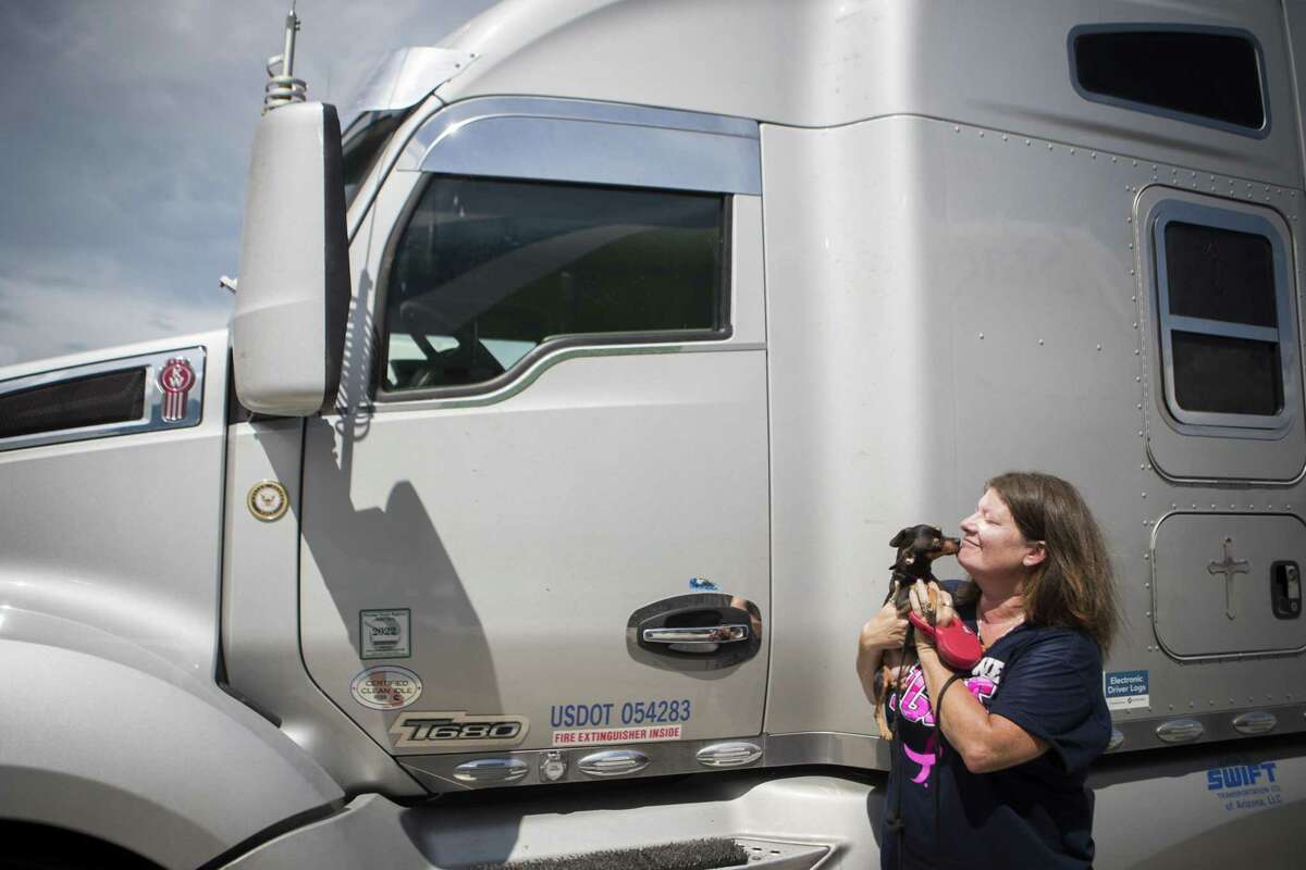 Jill Cummings, 49, from Tennessee gets lick by her dog Chaos at the Port Auto Truck Stop in La Porte, Monday, Aug. 27, 2018. Cummings is a long haul trucker who shares the wheel with her husband. She believes the excess of government regulations is making it harder for truckers to make a comfortable living and is discouraging the younger generation into getting in the business.
