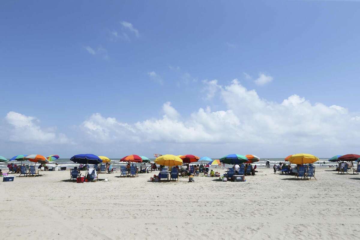 People enjoy a summer day on Stewart Beach in this June file photo. The temporary blue water off drove a a surge in tourism to Galveston. ( Yi-Chin Lee / Houston Chronicle )