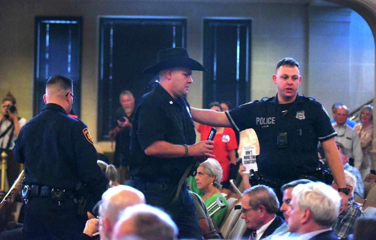 Brandon Burkhart, president of This Is Texas Freedom Force, is escorted out after an outburst during a meeting of the Alamo Citizen Advisory Committee on the proposed Alamo plan in City Council chambers on Thursday, Aug. 30, 2018. The committee approved seven resolutions supporting key concepts of the plan presented for the historic mission and battle site.