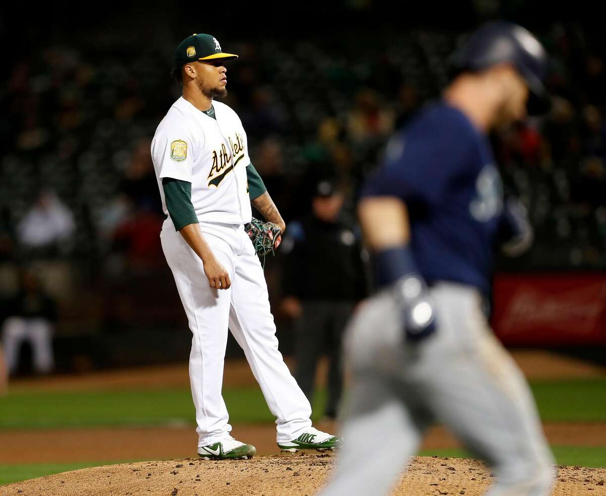 Oakland Athletics' starting pitcher Frankie Montas looks away as Seattle Mariners' Mitch Haniger rounds the bases after his solo home run in 4th inning in MLB game at Oakland Coliseum in Oakland, Calif. on Thursday, August 30, 2018.