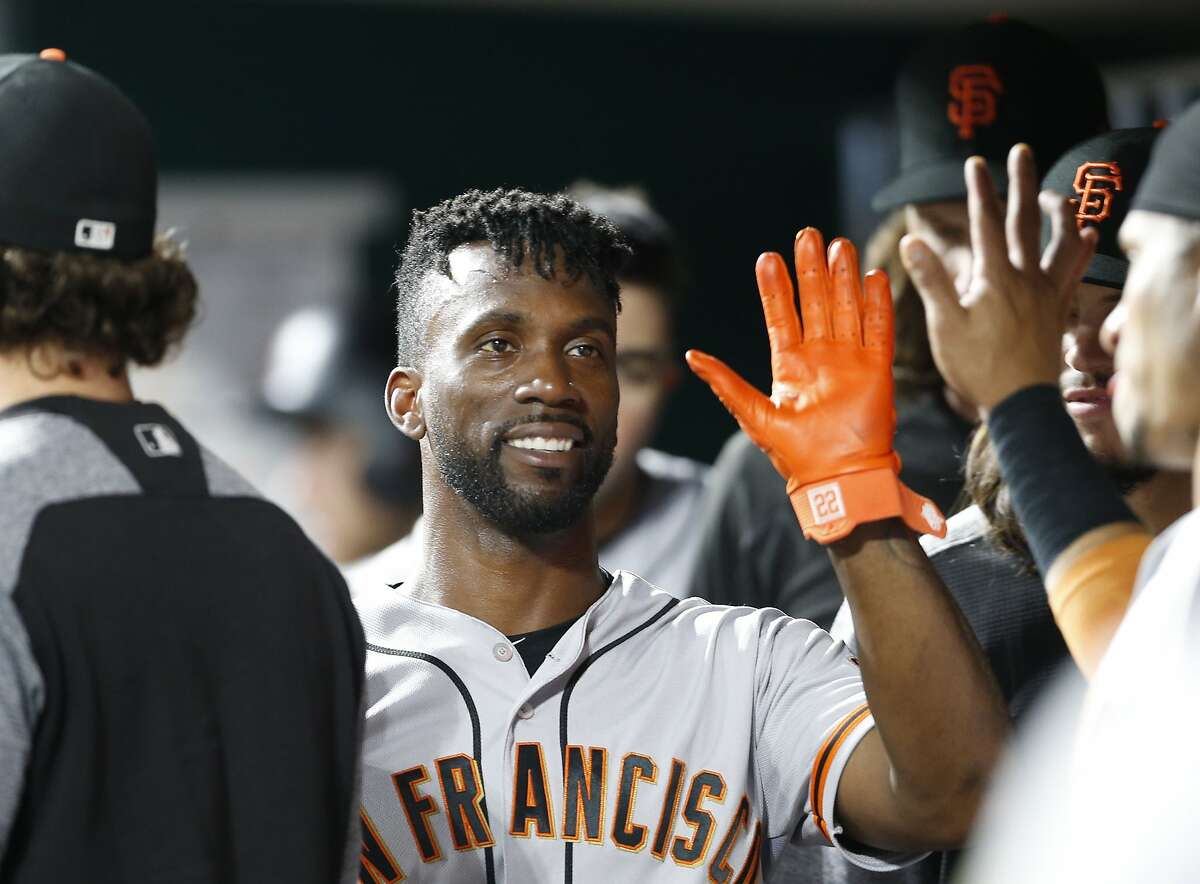 FILE - In this Aug. 18, 2018, file photo, San Francisco Giants' Andrew McCutchen, center, is congratulated in the dugout after scoring during the eighth inning of a baseball game against the Cincinnati Reds, in Cincinnati. (AP Photo/Gary Landers, File)