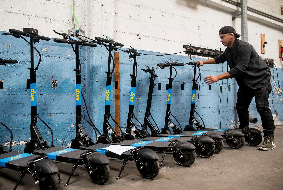 Skip technician Daniel Gutierrez lines up a row of scooters for deployment at the main Skip warehouse in San Francisco. After a temporary ban, scooters are about to hit the streets of San Francisco again.