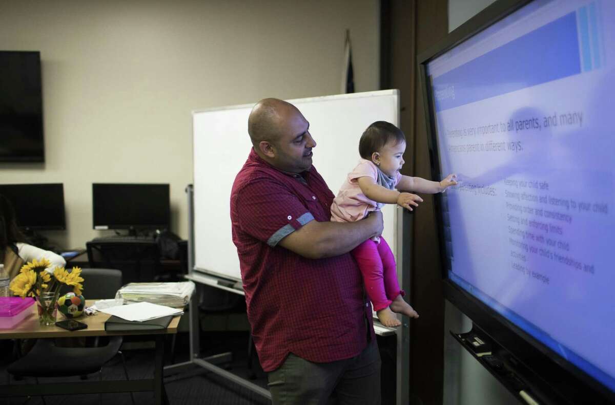 Ali Mohammed Saeed allows his daughter Sofia Saeed touch a monitor during a class on which refugees like Ali learn about what is expected of people living in the United States, Tuesday, Aug. 28, 2018, in Houston. Ali was an Iraqi translator for the U.S. military in some of the most dangerous areas between 2003-2007.