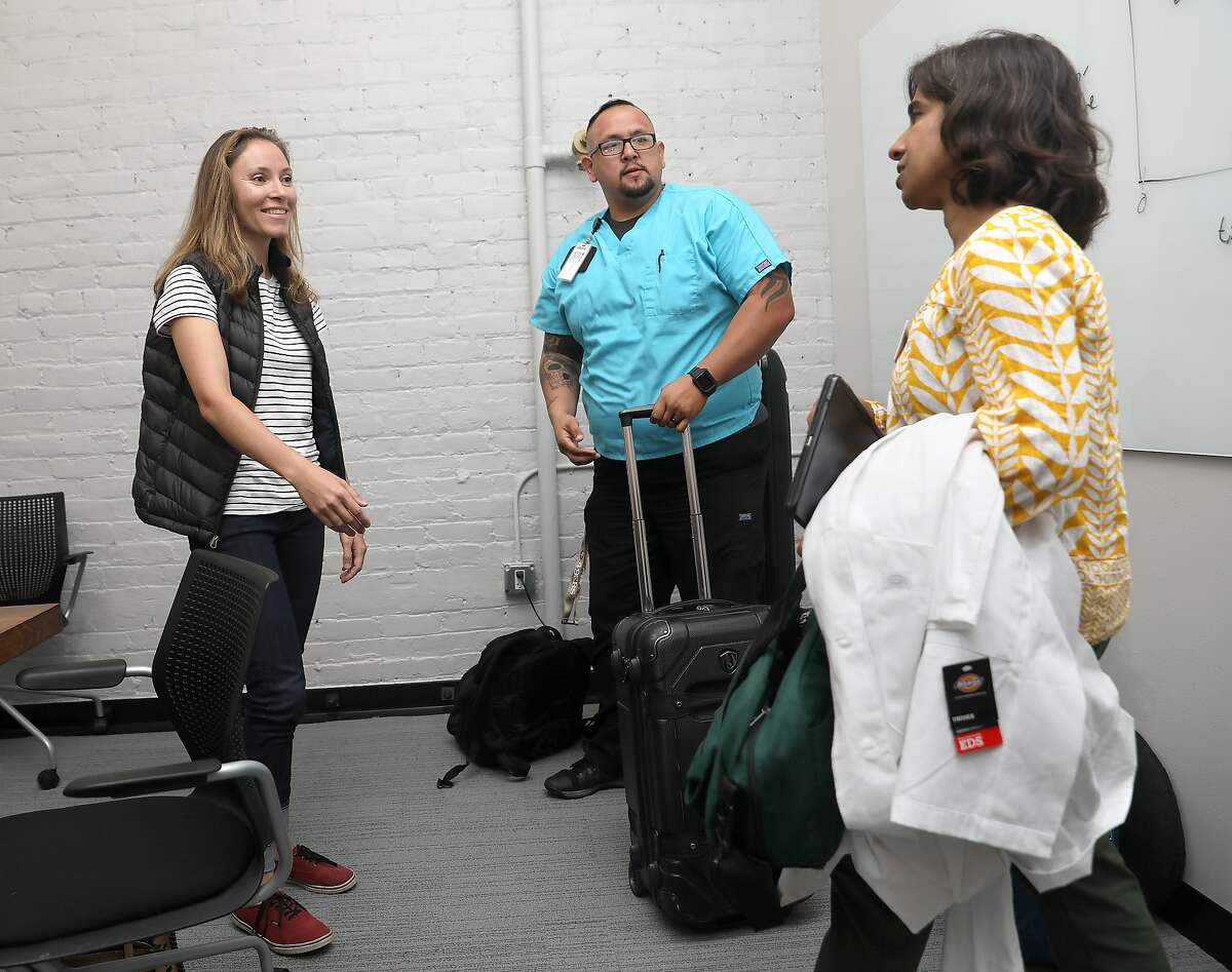 Strava product specialist Camila Ring (left) meets doctor Anju Goel (right) and certified medical assistant Dusty A. Sanabria (middle) in a conference room for her check up at work on Thursday, Aug. 30, 2018 in San Francisco, Calif. Heal, the three-year-old startup that provides doctors who make house calls, is growing by targeting large employers with the goal of sending doctors to see workers at the office.