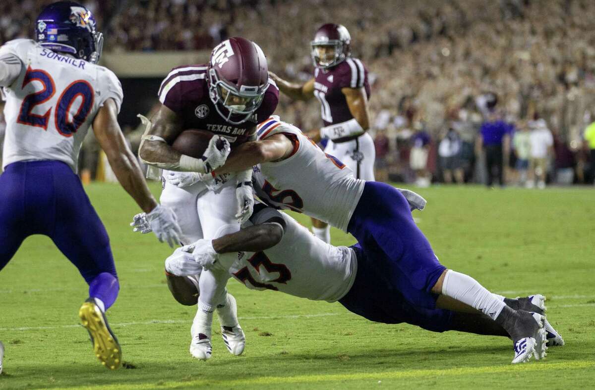Texas A&M running back Trayveon Williams (5) fights off Northwestern State defenders on his way to a touchdown during the first half of NCAA college football game Thursday, Aug. 30, 2018, in College Station, Texas. (AP Photo/Sam Craft)