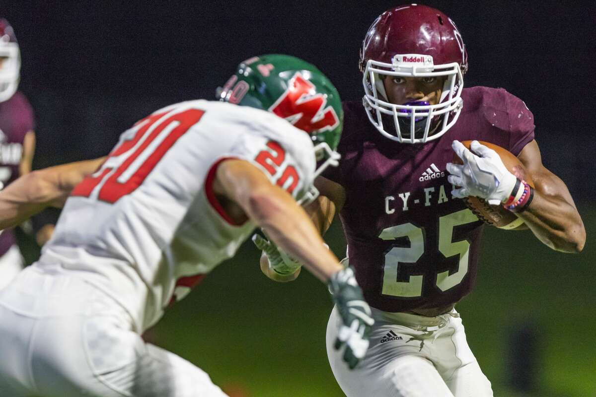 Cy-Fair running back Jaelon Woods (25) runs through the tackle of The Woodlands defensive back Chase Taylor (20) to score his second rushing touchdown of a high school football game at Pridgeon Stadium on Friday, Aug 31, 2018, in Houston.