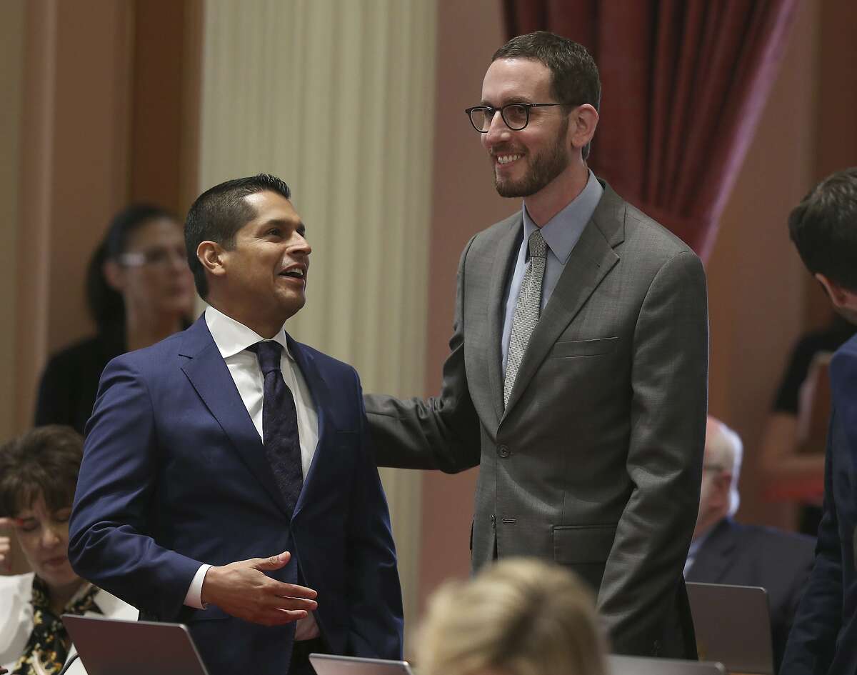 Assemblyman Miguel Santiago, D-Los Angeles, left, and state Sen. Scott Wiener, D-San Francisco, smile after their net neutrality bill was approved by the Senate, Friday, Aug. 31, 2018, in Sacramento, Calif. The bill, which seeks to revive regulations repealed last year by the Federal Communications Commission, now goes to Gov. Jerry Brown. (AP Photo/Rich Pedroncelli)