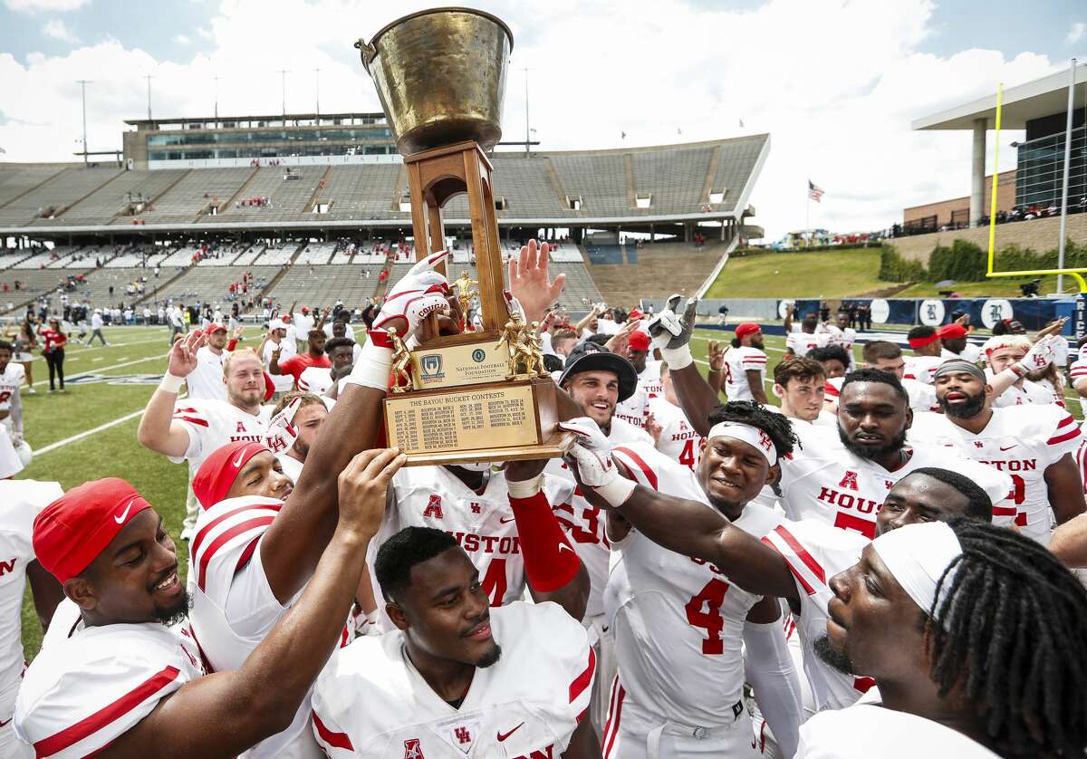 Houston football players hoist the Bayou Bucket after beating crosstown rival Rice 45-27 in an NCAA football game at Rice Stadium on Saturday, Sept. 1, 2018, in Houston.