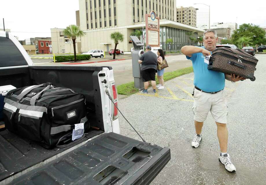 David Robertson puts luggage into his truck to take a couple to a cruise ship Monday, Sept. 3, 2018, in Galveston. He is the owner of the nearby Sharky's Tavern on 25th St. and saw people were needing rides to the cruise ship after street flooding forced many to seek alternative parking lots. He said he worked a few hours ferrying people from the parking lots to the ship. Photo: Melissa Phillip, Staff Photographer / © 2018 Houston Chronicle