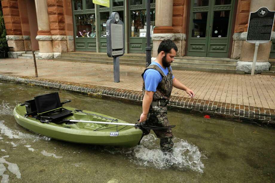 Tyler Hatfield pulls his boat along The Strand Monday, Sept. 3, 2018, in Galveston. He said he was sightseeing and he paddled along the street until the water became too shallow. Photo: Melissa Phillip, Staff Photographer / © 2018 Houston Chronicle