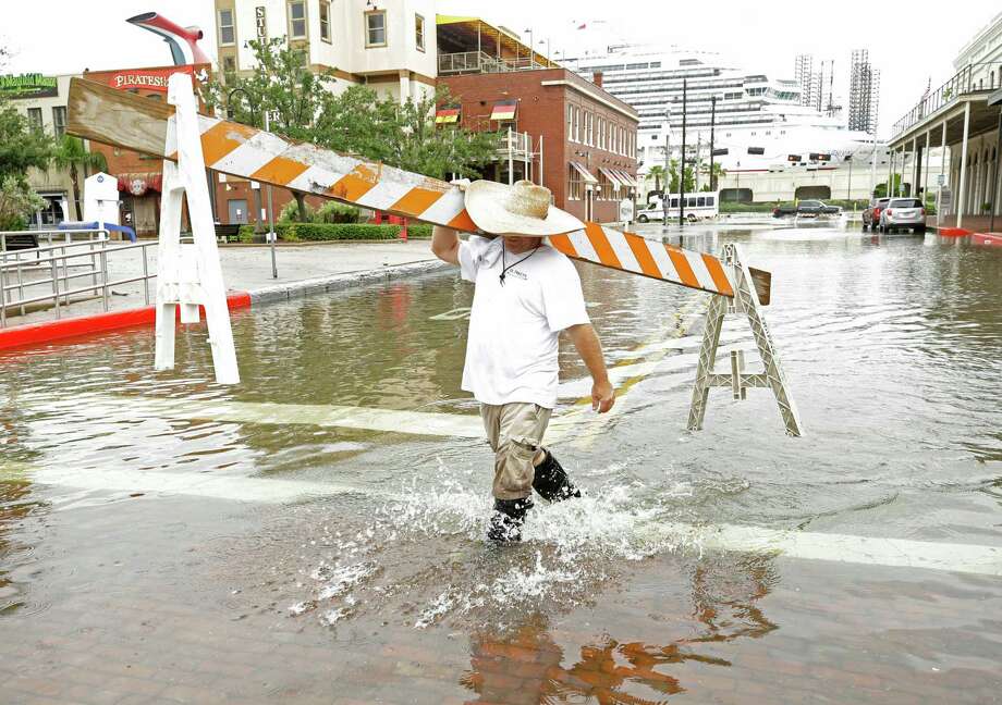A man carries a barricade to block the street along The Strand after heavy rain flooded many roadway Monday, Sept. 3, 2018, in Galveston. Photo: Melissa Phillip, Staff Photographer / © 2018 Houston Chronicle