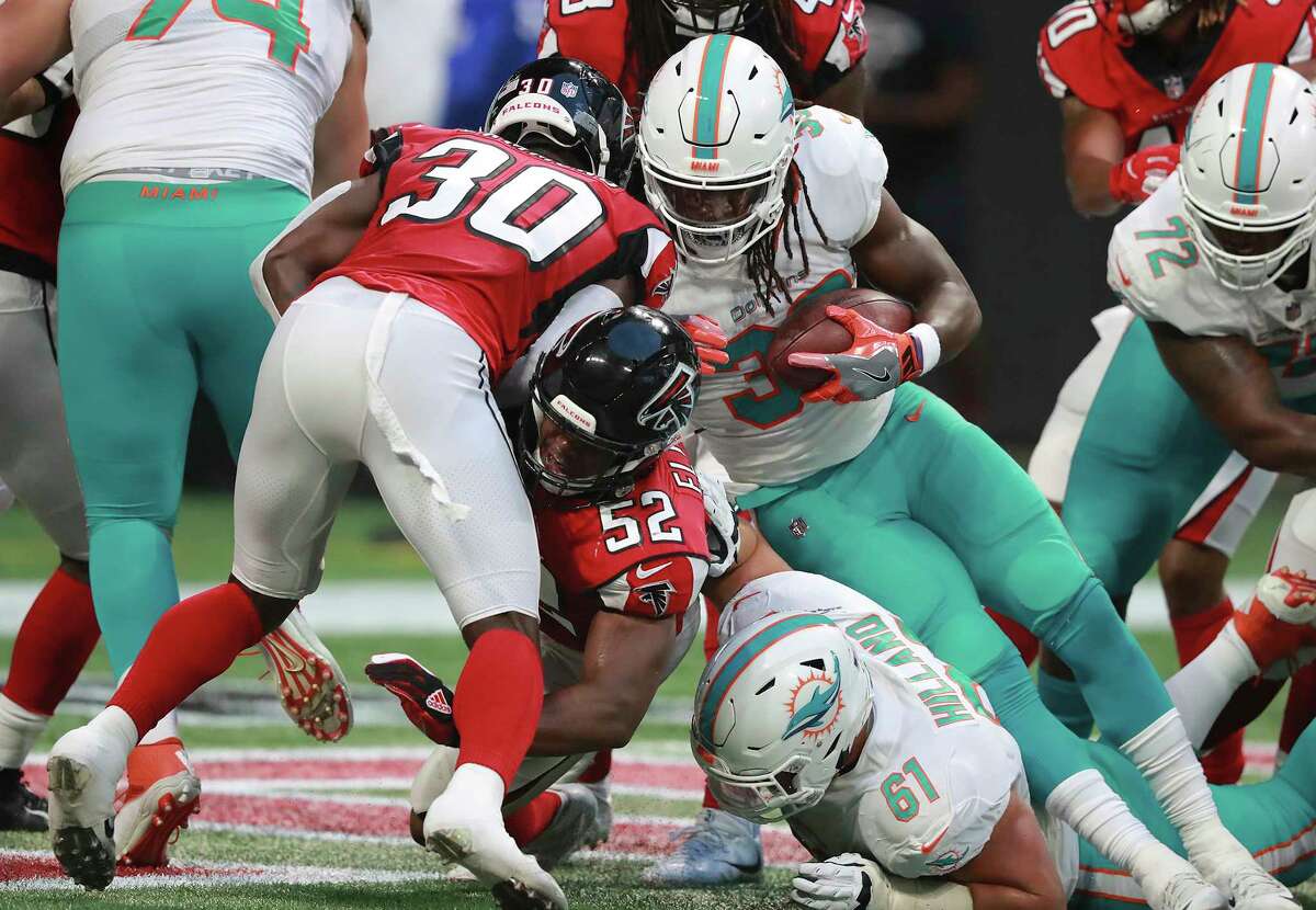 Atlanta Falcons Chris Lammons (30) and Emmanuel Ellerbee (52) cannot stop Miami Dolphins running back Buddy Howell (38) from scoring on short yardage during the first quarter in a preseason NFL football game Thursday, Aug. 30, 2018, in Atlanta. (Curtis Compton/Atlanta Journal-Constitution via AP)