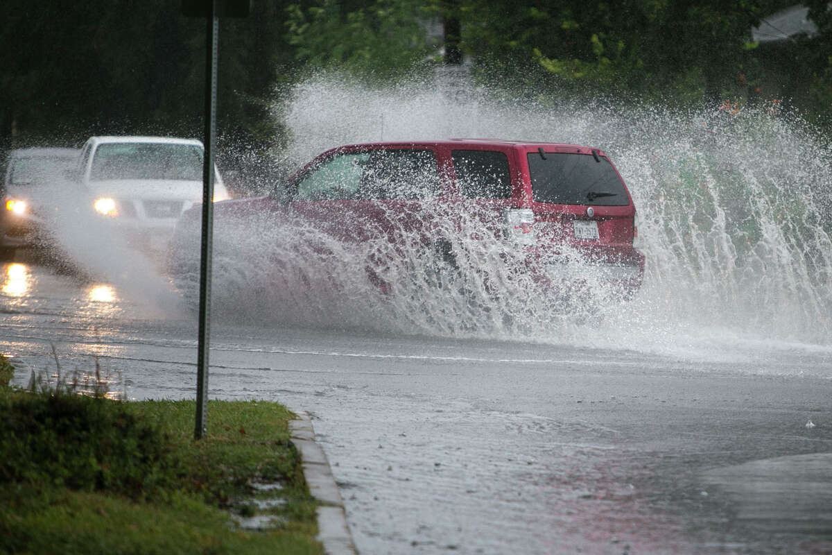 A car plows through water at the intersection of Fredricksberg and North Calaveras in San Antonio following heavy rains on Tuesday, Sept. 4, 2018.