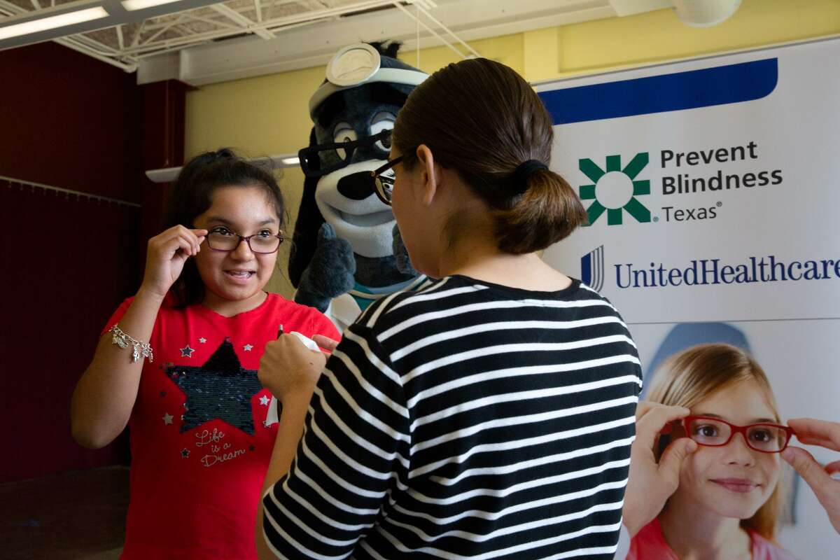 Rubi Camarena is cheered on by Dr. Health E. Hound as she receives a free vision screening from a certified pediatric vision screener with Prevent Blindness Texas, as part of a back-to-school health event at the BakerRipley Leonel Castillo Community Center in Houston. UnitedHealthcare provided a $5,000 grant to Prevent Blindness Texas for the local event.