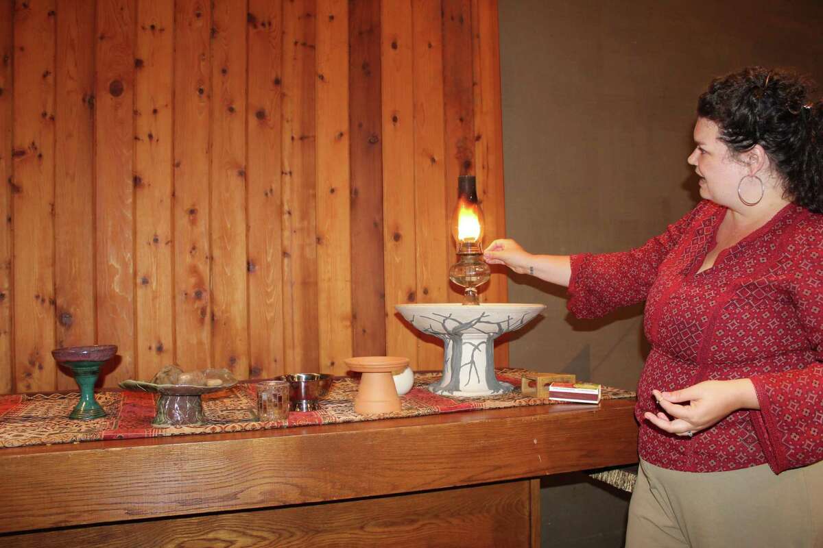 Northwoods Unitarian Universalist Church minister, The Rev. Sarah Prickett, lights her congregation’s flaming chalice on the altar. The flaming chalice, Prickett explained, is one of the most prominent symbols for the religion.