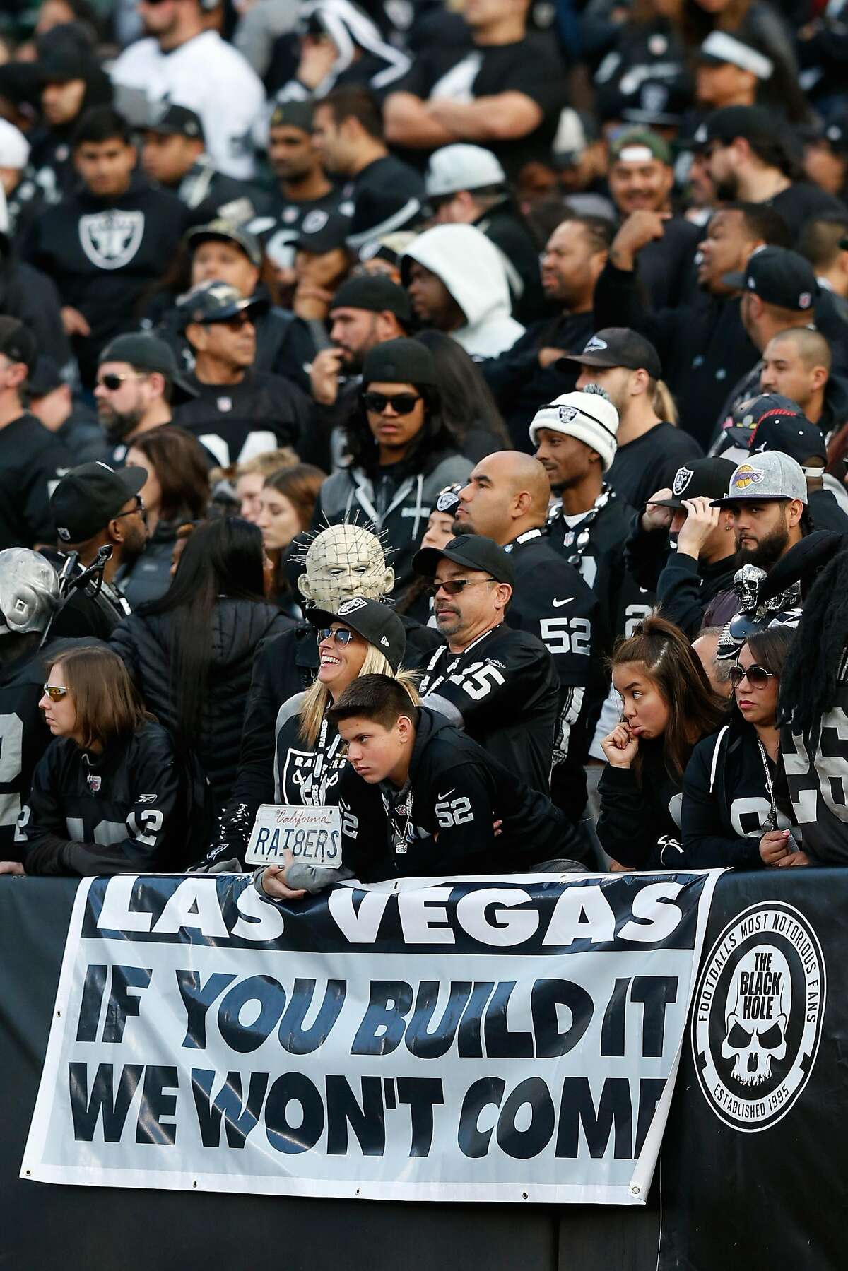 OAKLAND, CA - NOVEMBER 27: Oakland Raiders fans stand behind a sign referencing a potential move by the team to Las Vegas during their NFL game against the Carolina Panthers on November 27, 2016 in Oakland, California. (Photo by Lachlan Cunningham/Getty Images)