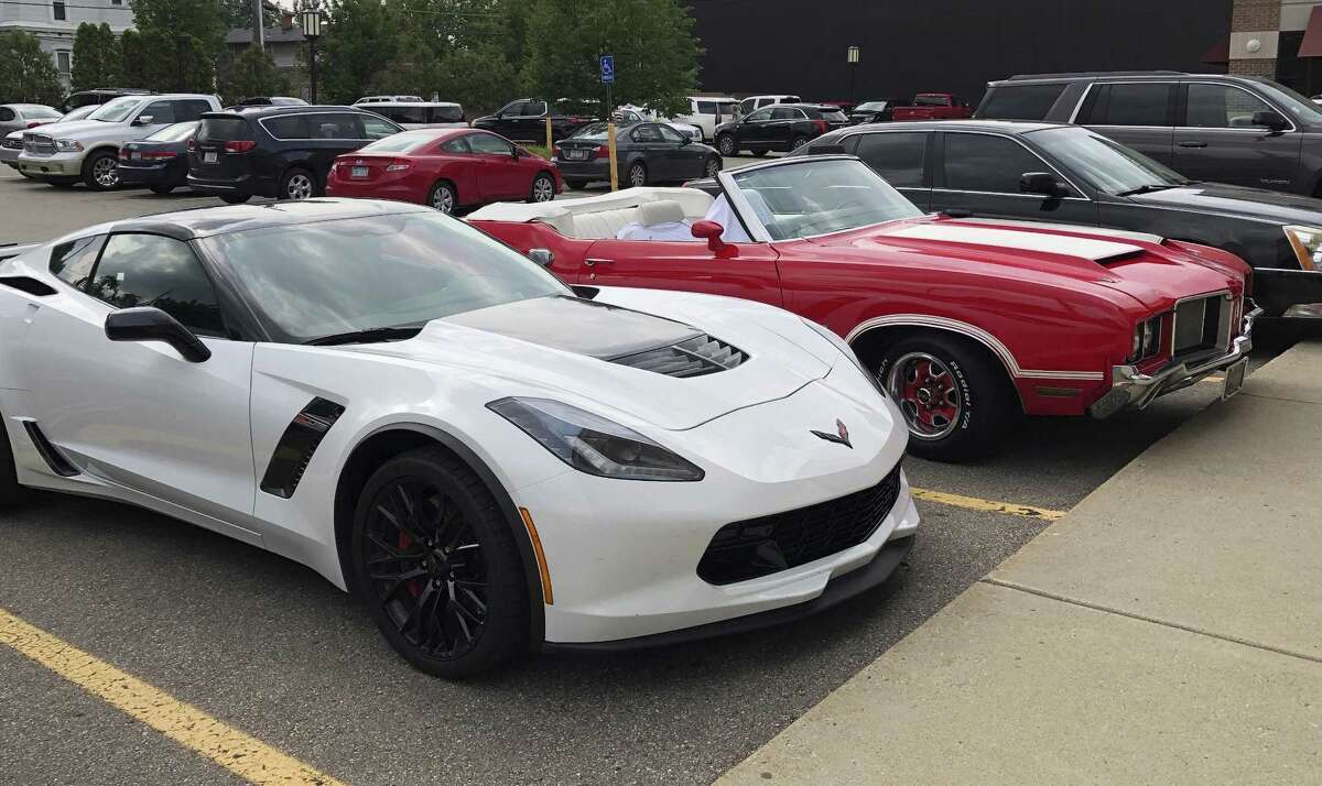 In this Aug. 18, 2018 photo, a Corvette Z06 is seen parked next to an Oldsmobile Cutlass in Birmingham, Mich. Muscle car fans consider the Ford Mustang, Chevrolet Camaro and Corvette and the Dodge Challenger and Charger to be the mainstays of Detroit performance cars. But their combined sales fell 7 percent in 2016, 11 percent last year, and are down almost 10 percent for the first half of 2018, according to numbers provided by Kelley Blue Book.
