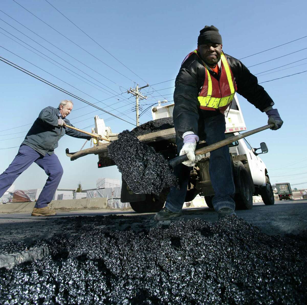 Reg0504 Photo-Peter Casolino New Haven-- New Haven Public Works employees Gary Poole, front and Dennis Chapman fill potholes along Stiles Street in New Haven with "Cold Patch." Photo-Peter Casolino